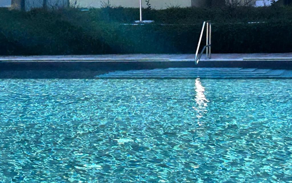 a pool of blue water with a stair in it at Casa Chiaretto in Moniga