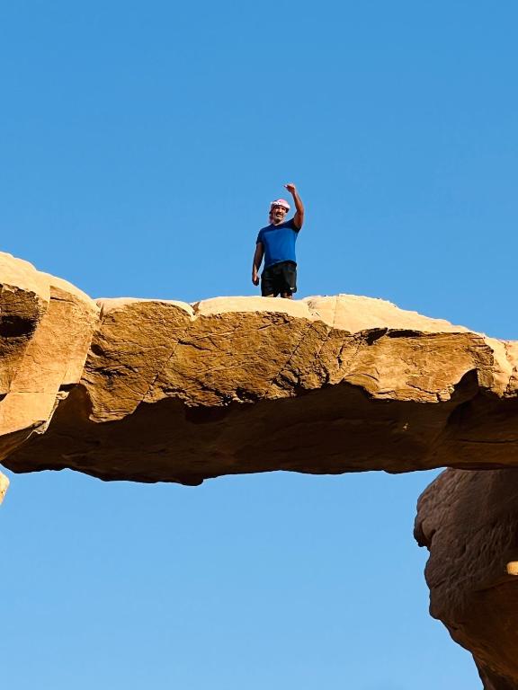 un uomo in piedi in cima a una formazione rocciosa di Desert Key Camp a Wadi Rum