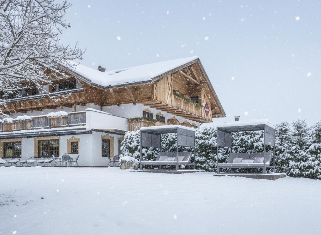a house covered in snow in front at Boutique Hotel Eggele in San Candido