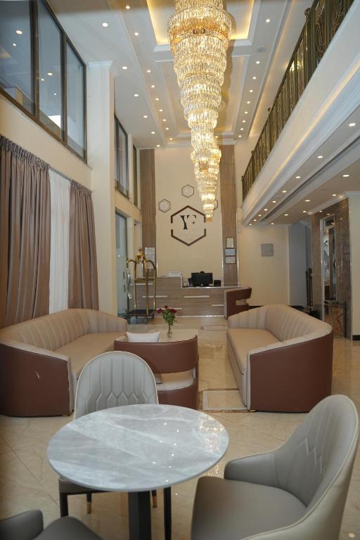 亚的斯亚贝巴Yofel Hotel Bole的大堂配有沙发、桌子和吊灯