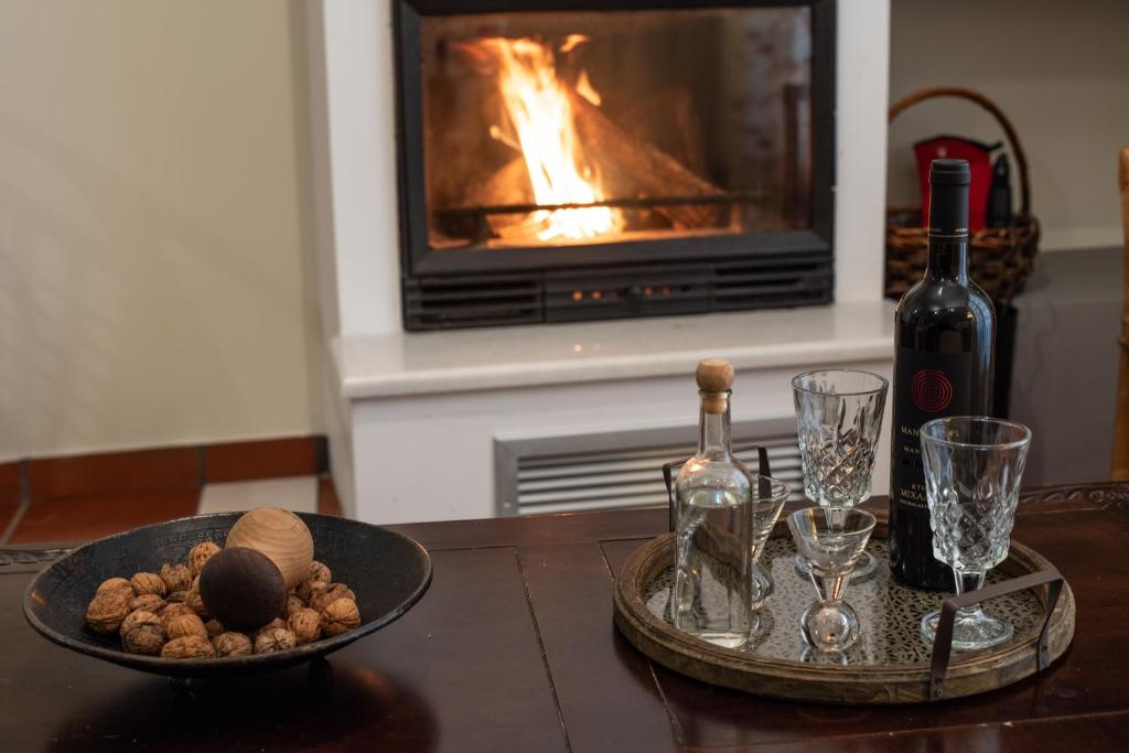 - une table avec une bouteille de vin et une assiette de nourriture dans l'établissement Snow Chalets Parnassos Arachova's Nest, à Arachova