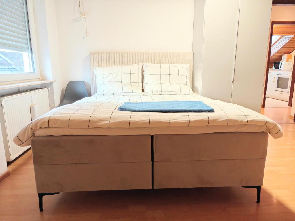 a large bed in a bedroom with a blue blanket on it at Fmi35 in Rüsselsheim