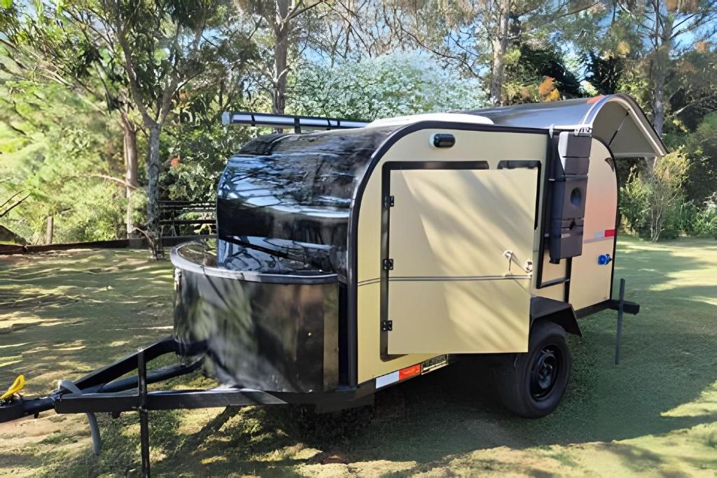 伊塔蒂巴Quinta do Vale - Mini-trailer: caiaque, lago, standup, cascata, piscina的一辆小型拖车停在田野里