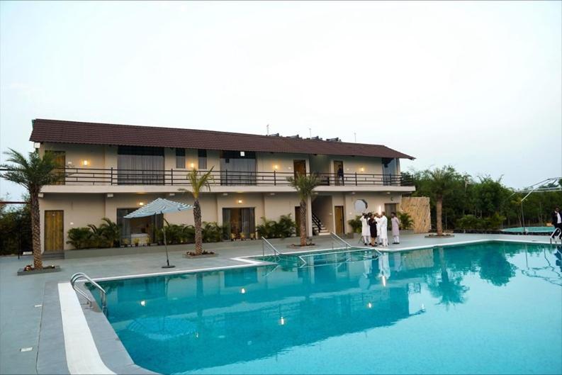 Una gran piscina azul frente a un edificio en A1 Tiger Resort, en Kolāra