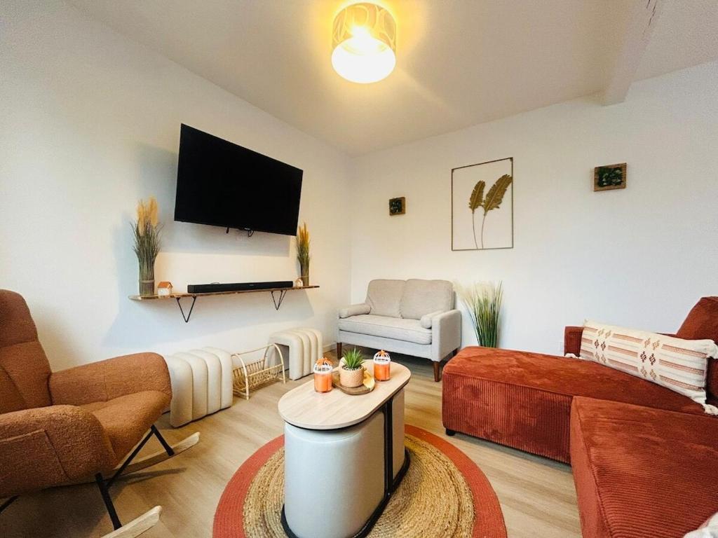 a living room with a couch and a tv at Casa Les Ponts de Cé in Les Ponts-de-Cé