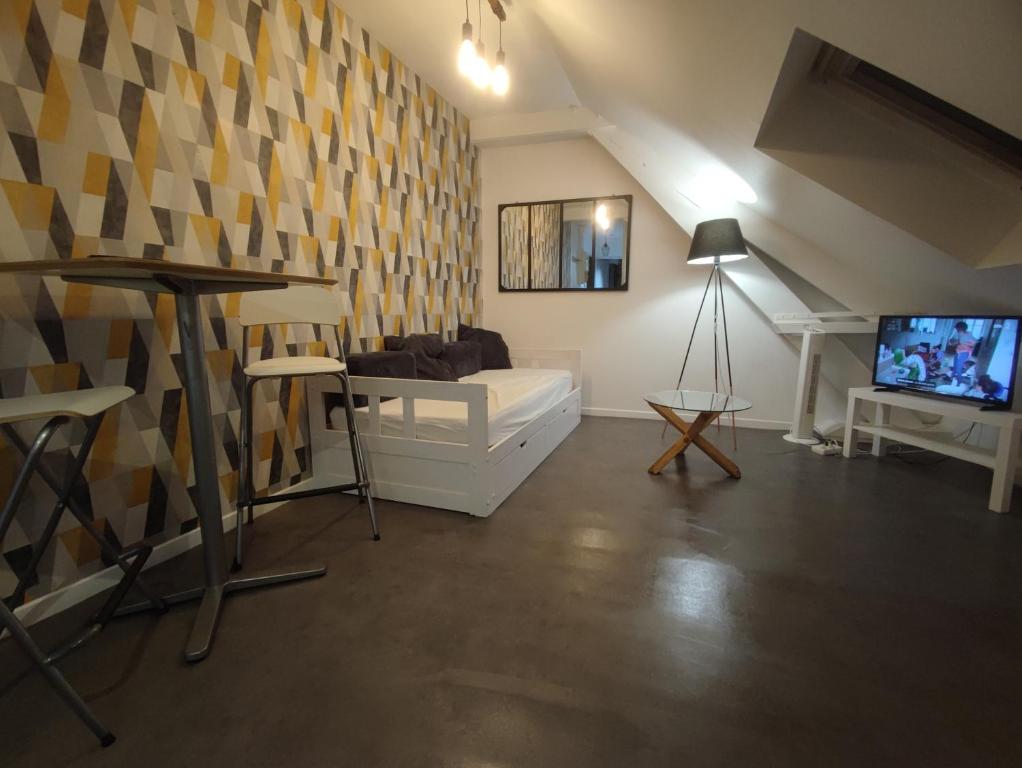 a living room with a couch and a tv at TOK TOK A5 Appartement 1Ch Proche toutes commodités in Annoeullin