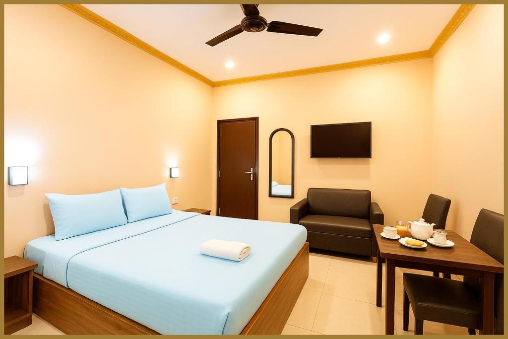 une chambre avec un lit, une chaise et un bureau dans l'établissement Sayan Lane Road Manshree Palace Resort- Fully Air Conditioning Room# Prime Location# Fully Air Conditioning Room# Prime Location# Parking And Free Wifi- Premium Best Hotel In puri, à Purî