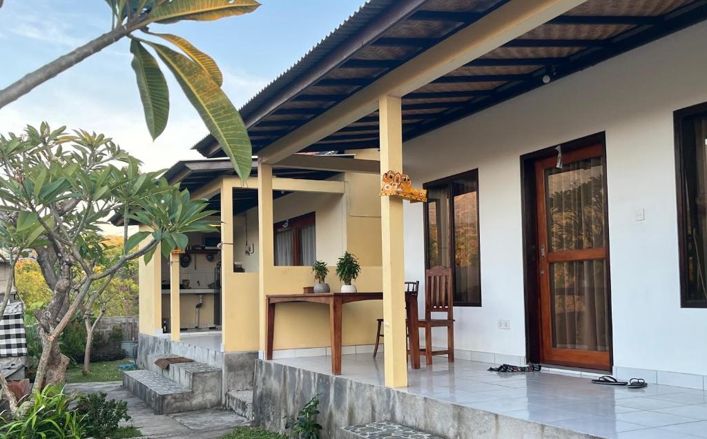 une maison avec une table sur la terrasse couverte à l'avant dans l'établissement Dewenten Home Stay With View Mount Agung, à Tulamben