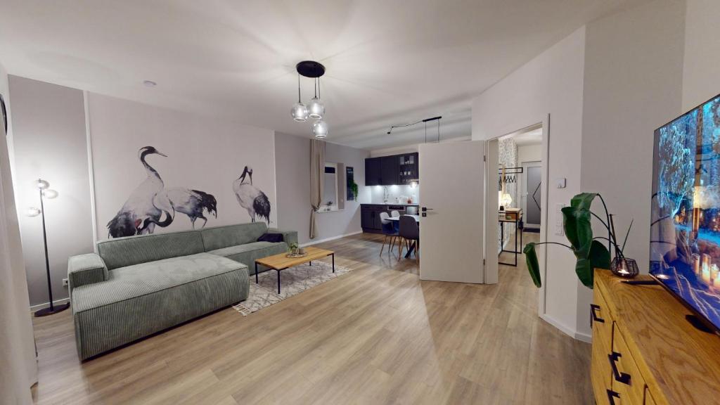 ein Wohnzimmer mit einer grünen Couch und ein Wohnzimmer mit einem Tisch in der Unterkunft Arche Noah Unterkunft in Westoverledingen