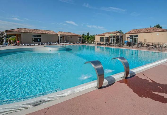 a large swimming pool with blue water at Maison Les Demeures du Ventoux in Aubignan