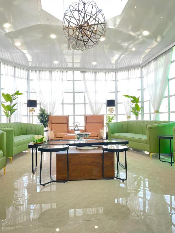 a living room with green couches and a coffee table at ASNB Farm House 2BHK with Pool in Multan