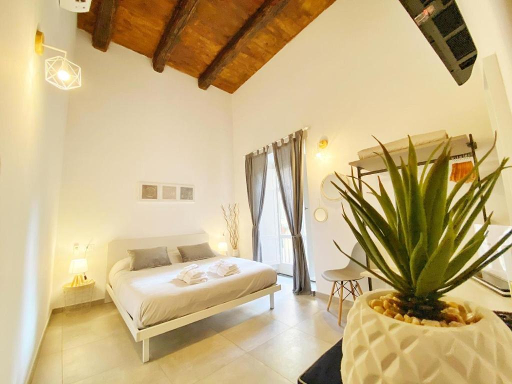 萨莱诺Il Duomo - Relais di Charme的一间带床和盆栽的卧室