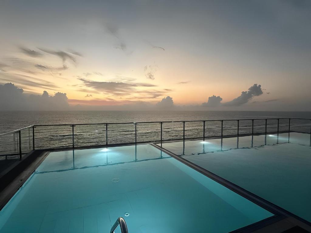 a swimming pool with the ocean in the background at Sea View Apartment in Colombo -Dehiwala in Dehiwala