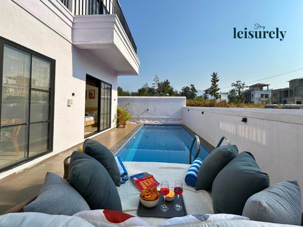 Stay Leisurely Casa Astre 3BHK, Karjat في كارجات: حديقة خلفية مع حمام سباحة ومنزل