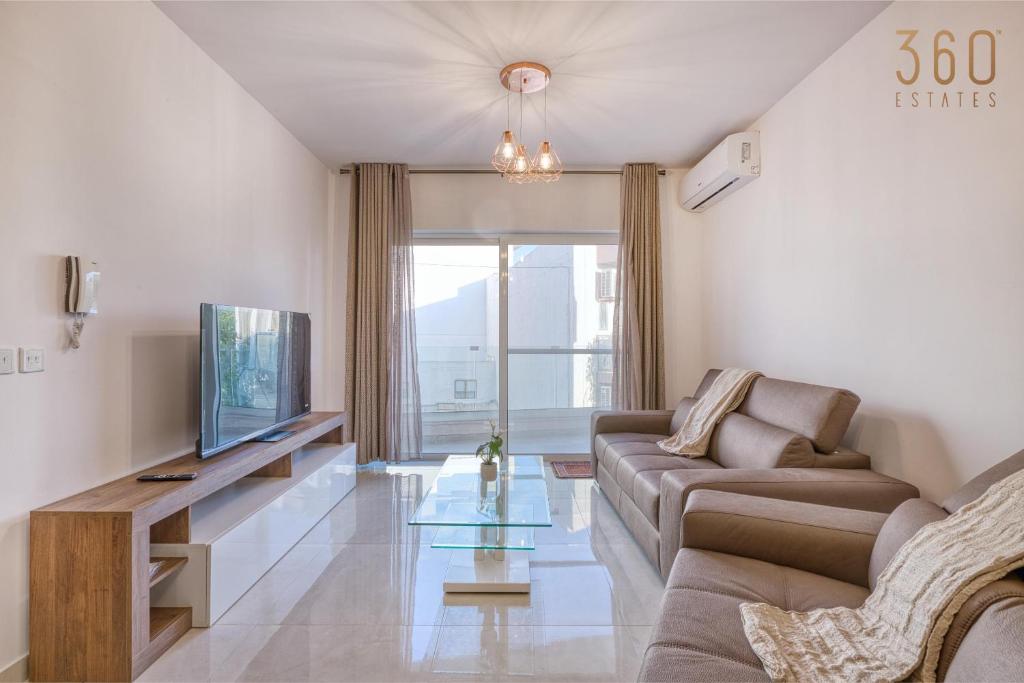 Una sala de estar con un sofá y un televisor en Beautiful 3BR homes with comfy beds, WIFI & AC by 360 Estates, en Naxxar