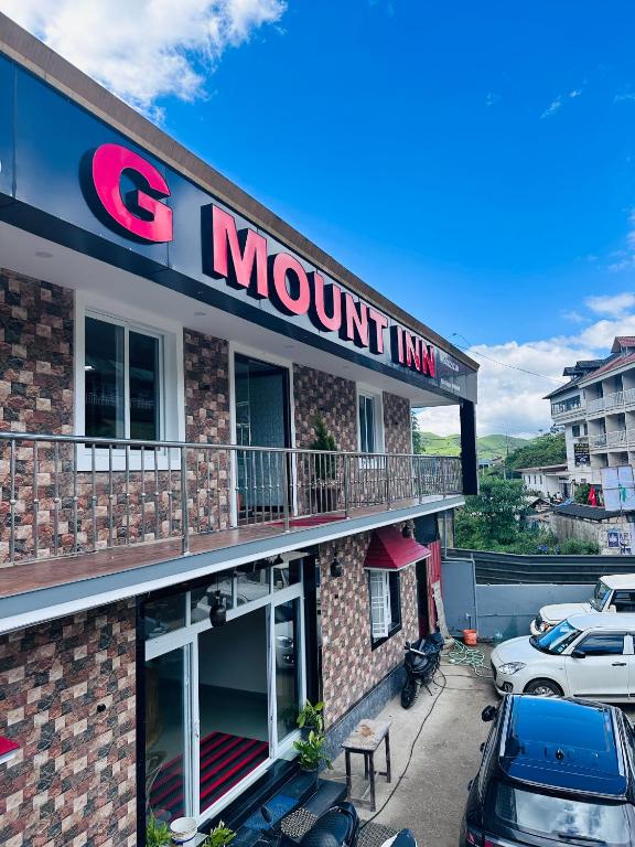 a mountain inn with cars parked outside of it at G Mount inn in Munnar