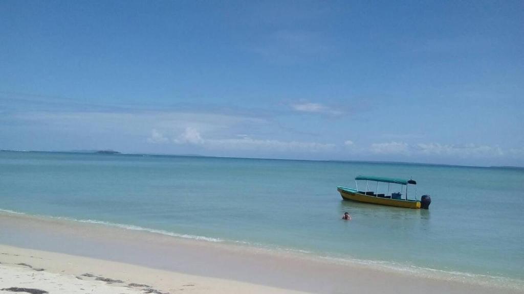 un barco sentado en el agua en una playa en Chalet over the Caribbean sea, en Istmito