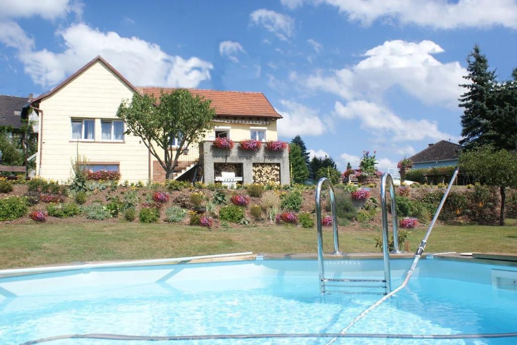 ein Swimmingpool mit einem Haus im Hintergrund in der Unterkunft Wohnung Du Coucou In Lichtenberg in Lichtenberg