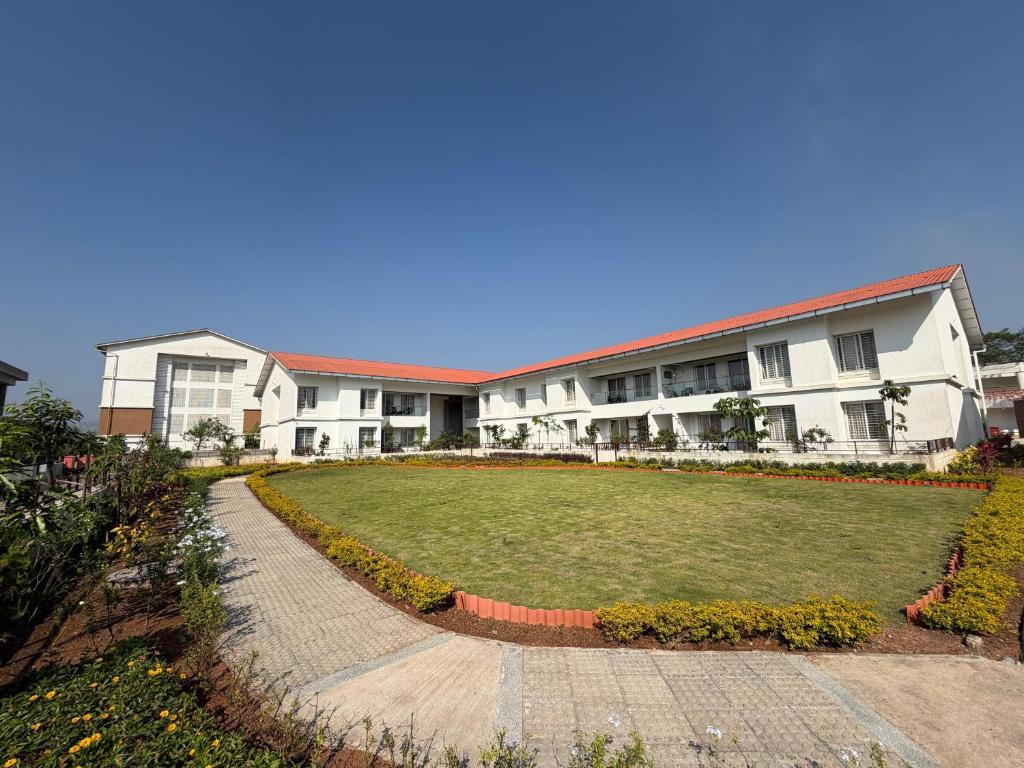 ein großes Haus mit einer großen Wiese davor in der Unterkunft Ovi Resort & Spa in Lonavla