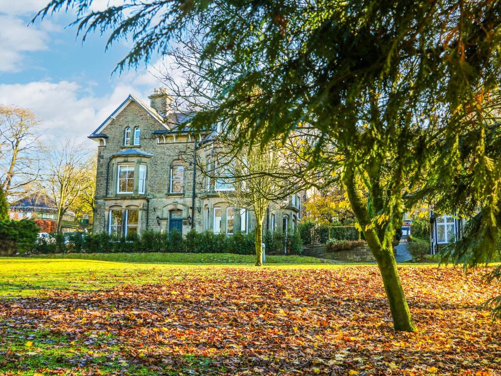 a large house with a tree in front of it at Chatsworth Suite in Buxton