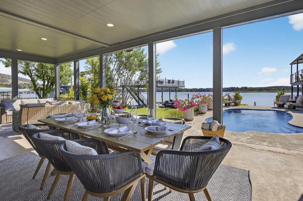 een tafel en stoelen op een patio met een zwembad bij All Decked Out and Concierge Services in Kingsland