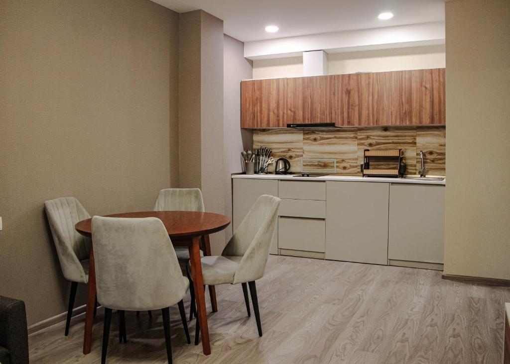 een keuken met een tafel en stoelen in een kamer bij Crystal Loft Bakuriani Apartment in Bakuriani