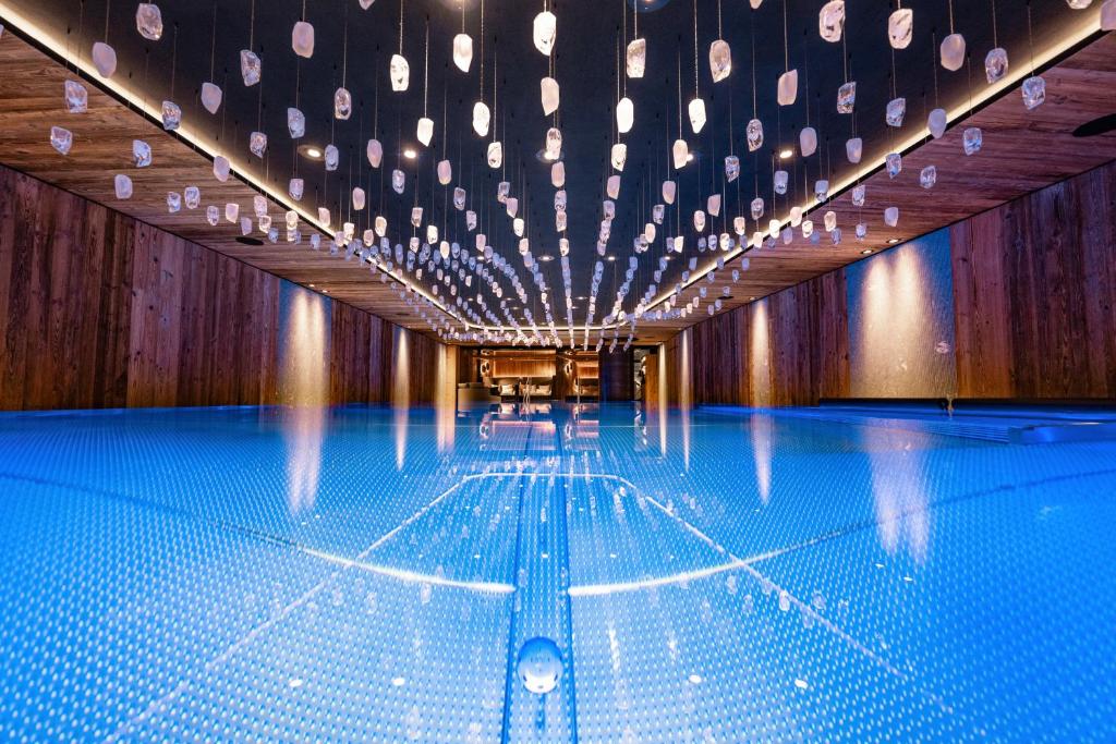 a swimming pool with lights on the ceiling at Tradition Julen Hotel in Zermatt