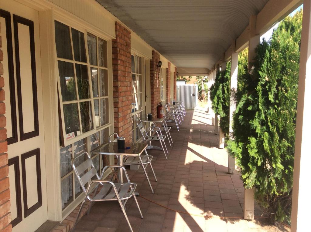 a patio area with chairs, tables and umbrellas at Kerang Motel in Kerang