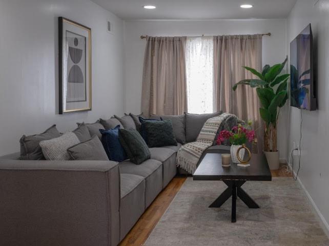a living room with a gray couch and a table at 3BR Comfort Hub Newark 15 mins NYC in Jersey City