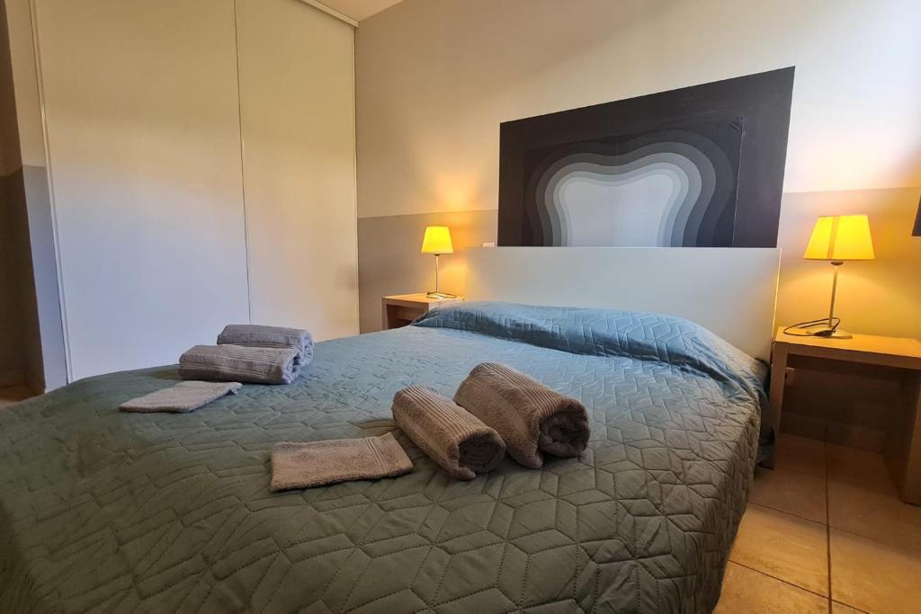 塞拉迪费罗Appartement climatisé dans une résidence avec piscine mer à pied的一间卧室配有一张带毛巾和两盏灯的床。