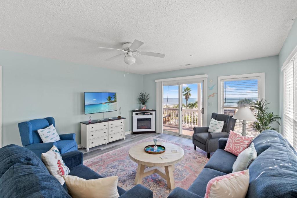 a living room with a blue couch and a table at Oceanfront 3BR with Stunning Views, Private Balcony and Pool in Myrtle Beach
