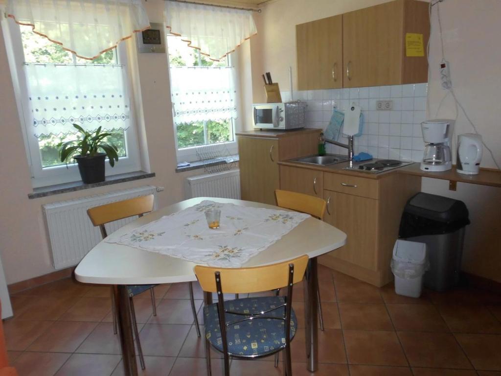 a kitchen with a white table and chairs in it at Wolfsgrund in Sayda