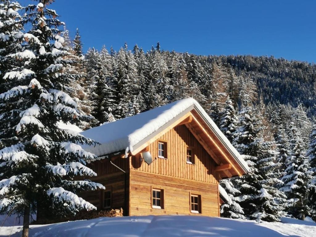 a log cabin with snow on the roof at Wirths Hütte in Innerkrems