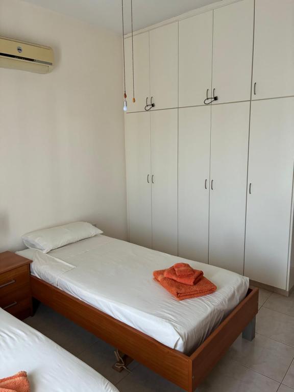 a bedroom with two beds and white cabinets at Venus205 in Paphos City
