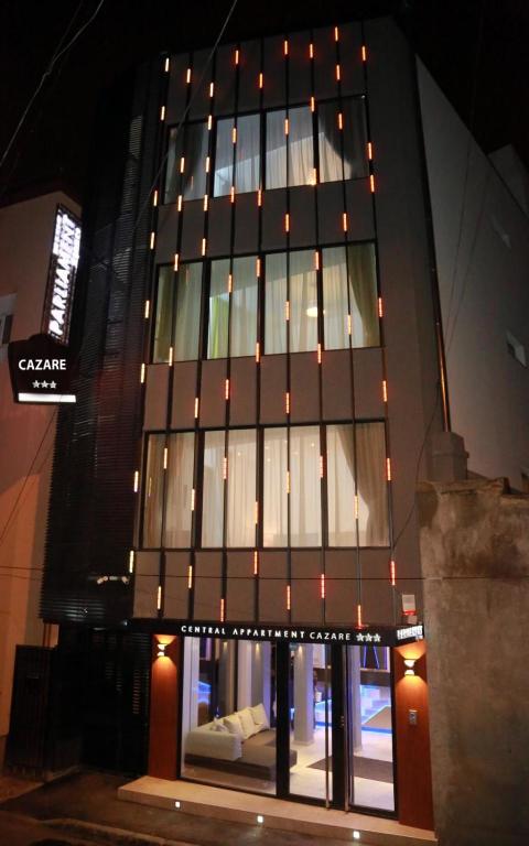 a tall black building with lit up windows at night at Parliament Square in Bucharest