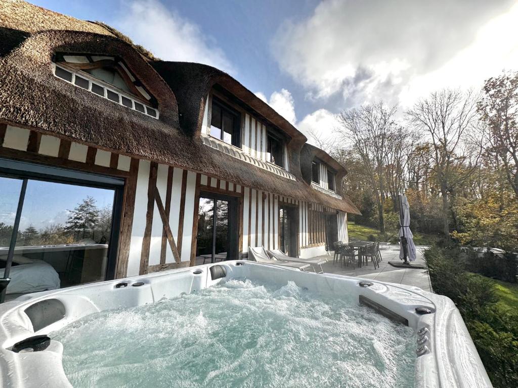 a hot tub in front of a house at Villa Pier'Art - Piscine Jacuzzi Tennis Vue Mer in Touques