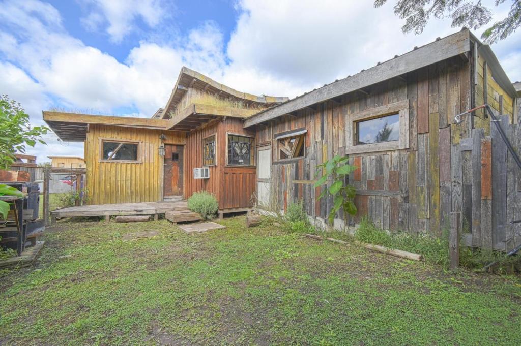 a wooden house with a fence in the yard at Cabaña Suri in Belén de Escobar
