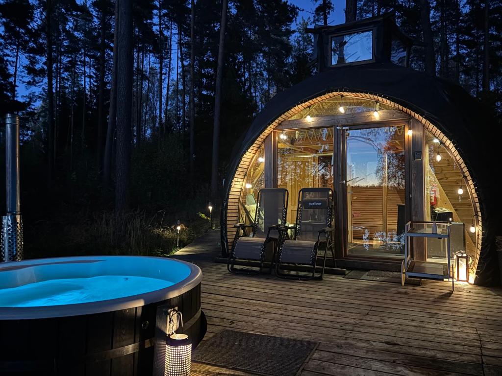 um gazebo com uma banheira de hidromassagem em frente em Nameliai Miškuose em Molėtai