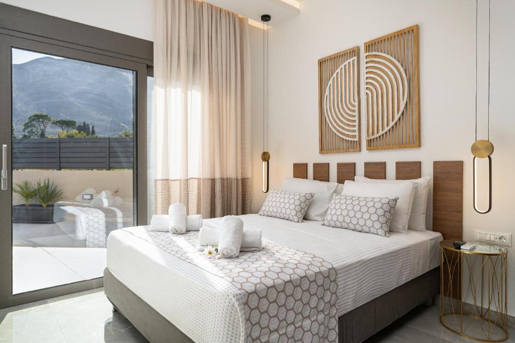 a bedroom with a large bed and a balcony at Stone Heaven Luxury Villa in Kournás