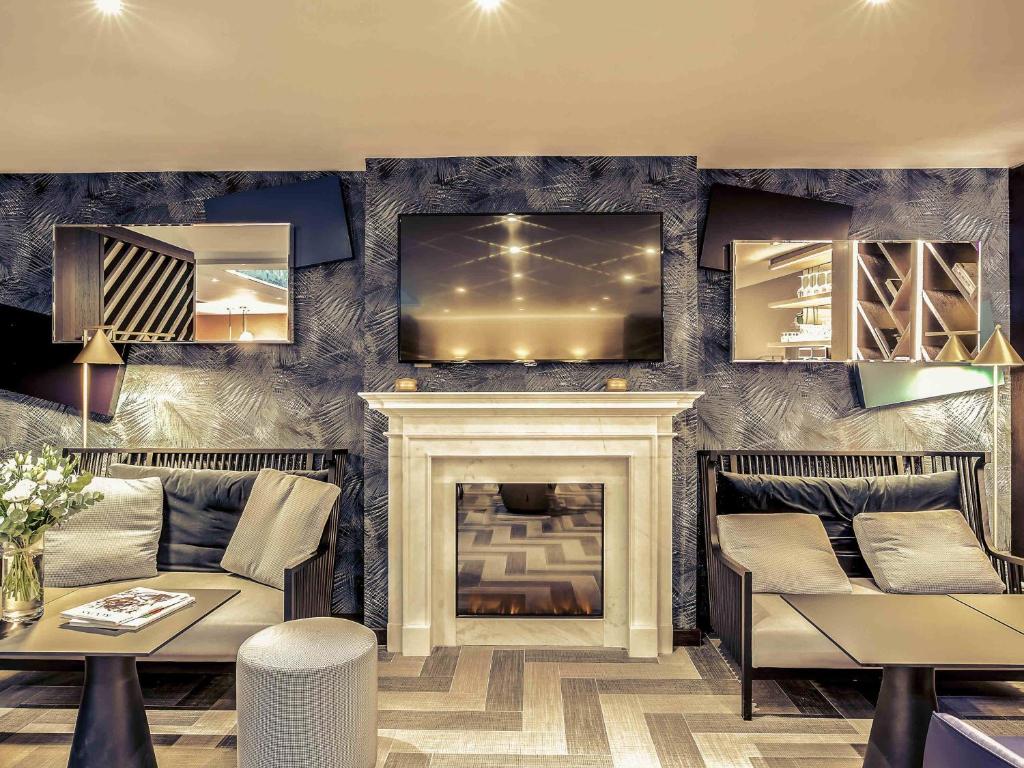 uma sala de estar com lareira e TV em Mercure Paris Arc de Triomphe Etoile em Paris