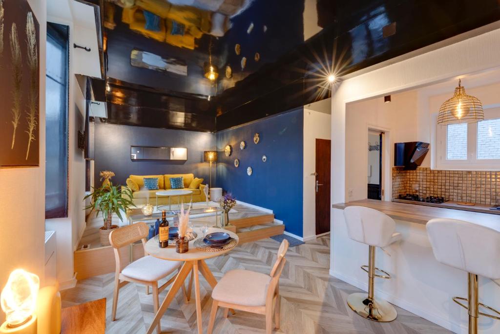 a living room with a table and chairs and a couch at L'Appart Cosy- Hyper centre- Vue sur la collégiale in Brive-la-Gaillarde