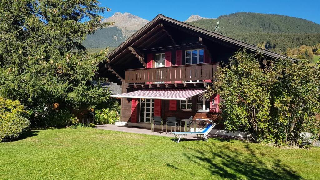 ein Haus mit einem Rasen davor in der Unterkunft Gemütliches Chalet zum Alleinbewohnen mit Top Garten & Bergblick, kostenloses WIFI, Ladestation für E-Autos in Grindelwald