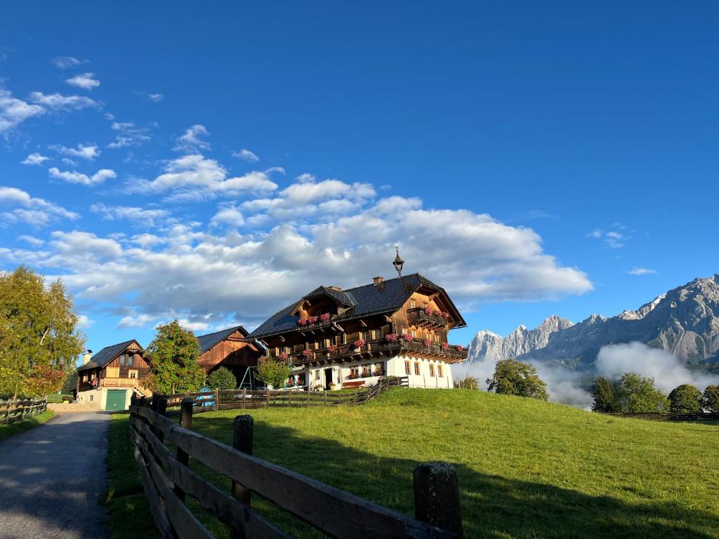 a house on a hill with mountains in the background at Pension Patz in Schladming