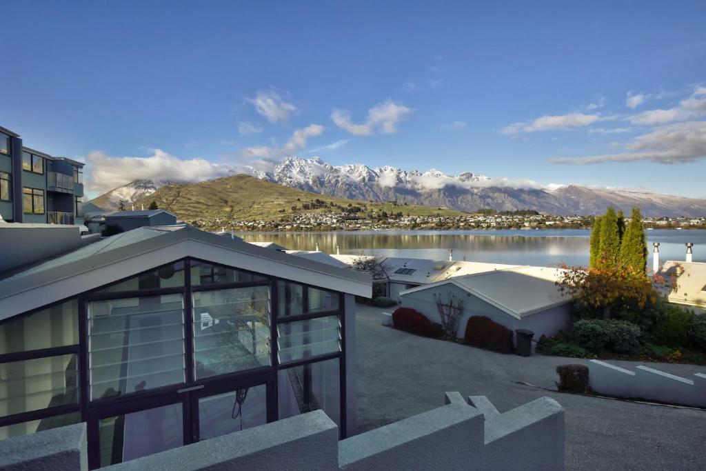 ein Haus mit Blick auf einen See und die Berge in der Unterkunft Central 2 bed Apt - views pool walk to town in Queenstown