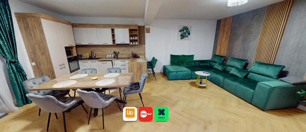 ein Wohnzimmer mit einem Tisch und einer grünen Couch in der Unterkunft Regina Urban Stay VRT in Şelimbăr