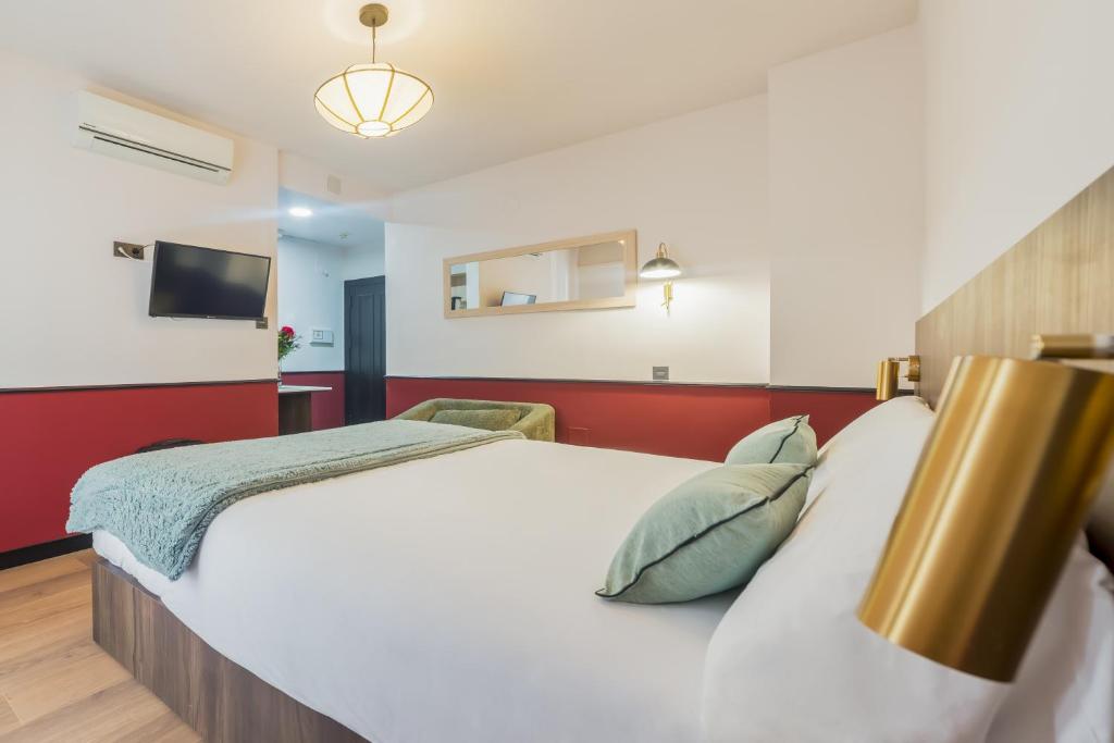 a bedroom with a white bed and a flat screen tv at Casa Lavanda in Granada