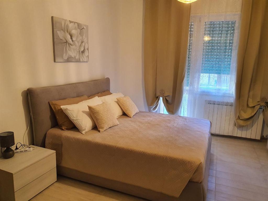 een slaapkamer met een bed met kussens en een raam bij Infinity Karla House 2 in Chioggia