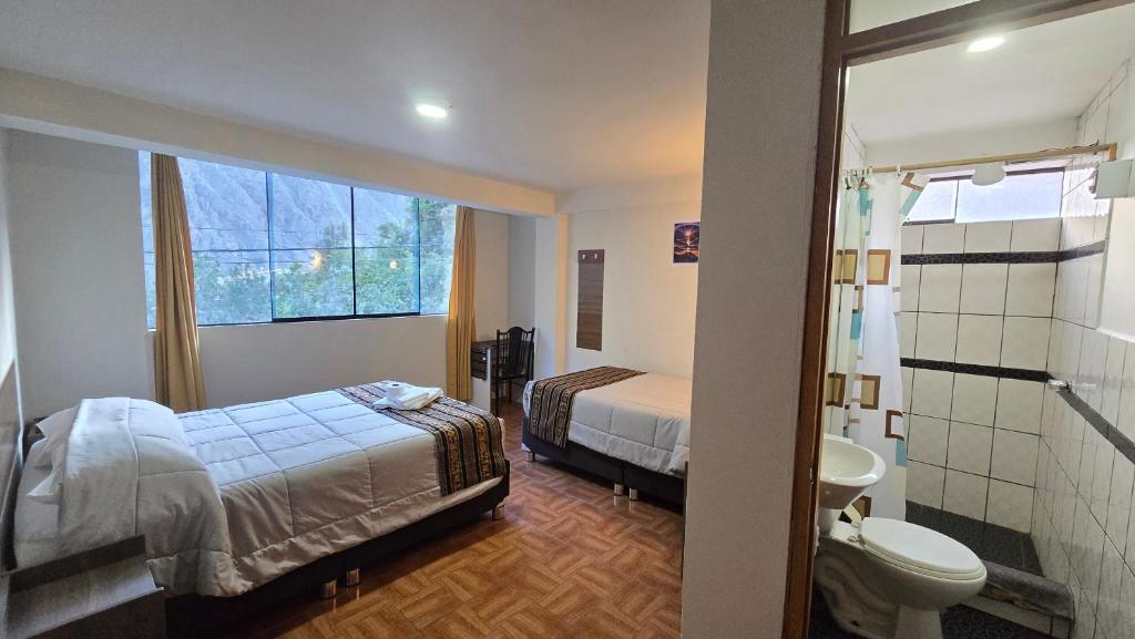 a bedroom with a bed and a bathroom with a toilet at Refugio Sagrado Boutique in Ollantaytambo