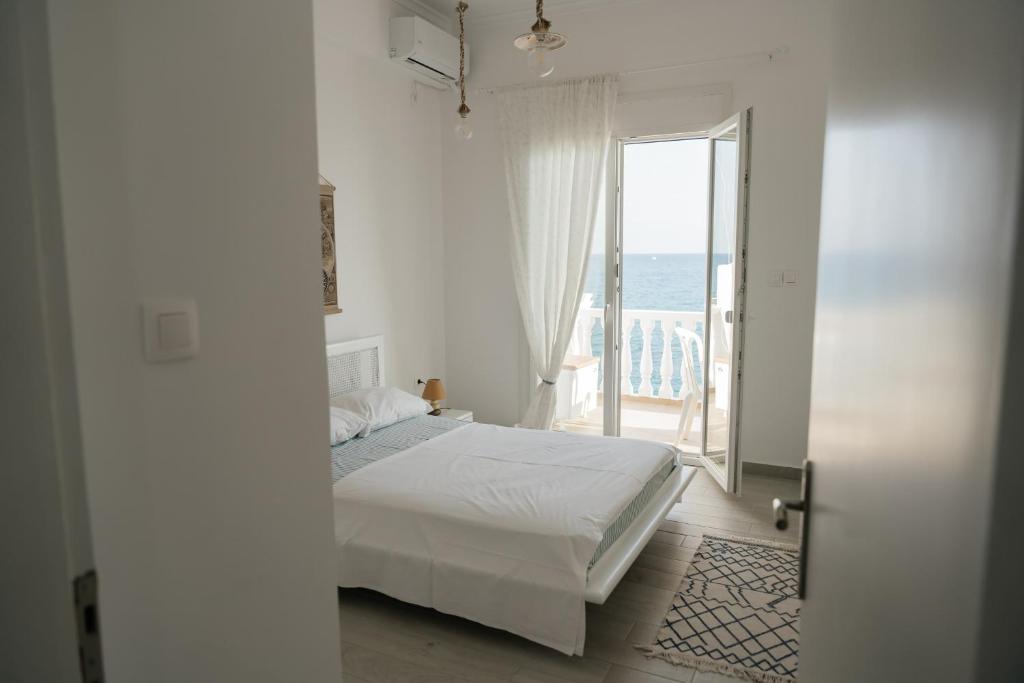 a bedroom with a bed and a view of the ocean at Irini in Mesochórion