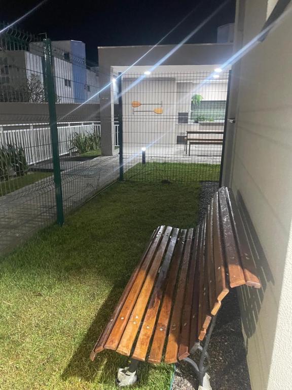 a wooden bench sitting on the side of a building at Apartamento Itapoá in Itapoa